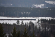 Mens et tog kjører forbi på den andre siden av åsen