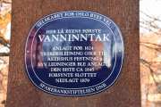 På den andre siden av elva kan vi se hvor det blå skiltet står, som forteller om stedet