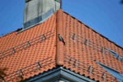 En fugl sitter på taket der borte