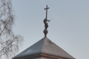Risbakken 1 Ris kirke. På toppen av tårnet er det et stort kors med en skulptur av St. Olav som dreper en drage, et symbol på kristendommens seier over hedenskapen. Skulpturen ble tegnet av arkitektene Berner og utført av Arthur Gustavson
