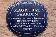 Dronningens gate 11 har et blått skilt som forteller oss litt mer