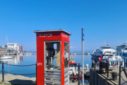 I 2023 sender Maiken meg bilder av den røde telefonkiosken som står ved havnepromenaden i Harstad