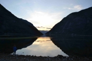 Fra stranden kan du se utover fjorden og følge solnedgangen