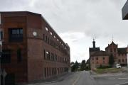 Til venstre ser vi gamle Hamars melkefabrikk som ble bygd i 1875 og på høyre side foran oss ligger bygningen til Hamar bryggeri som ble grunnlagt i 1856. Bygningen er vernet nå
