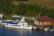 Langt der nede så ser jeg båten Telemarken ligger ved Akkerhaugen Brygge vest. Akkerhaugen brygge har siden 1870 vært benyttet av dampskipene som gikk her ved Norsjø og Sauarelva