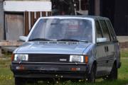 Bak et bygg står det en Nissan Prairie som er en første generasjon som ble produsert rundt 1985, kan faktisk settes i stand slik jeg ser det