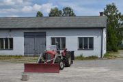 Fredag. Vi passerer forbi gamle industribygninger og traktoren som er en god gammel veteran står foran og har nok oppgaven med å rydde snø på vinteren