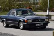 Men nå må jeg slutte å tøyse, de kommer på rekke og rad nå. Dette er en Mercedes-Benz 350 SL fra 1972 og både sjåfør og bil er kledd til 17 mai